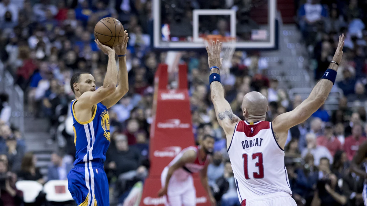 Stephen Curry lanza con los Warriors ante la defensa de Marcin Gortat.