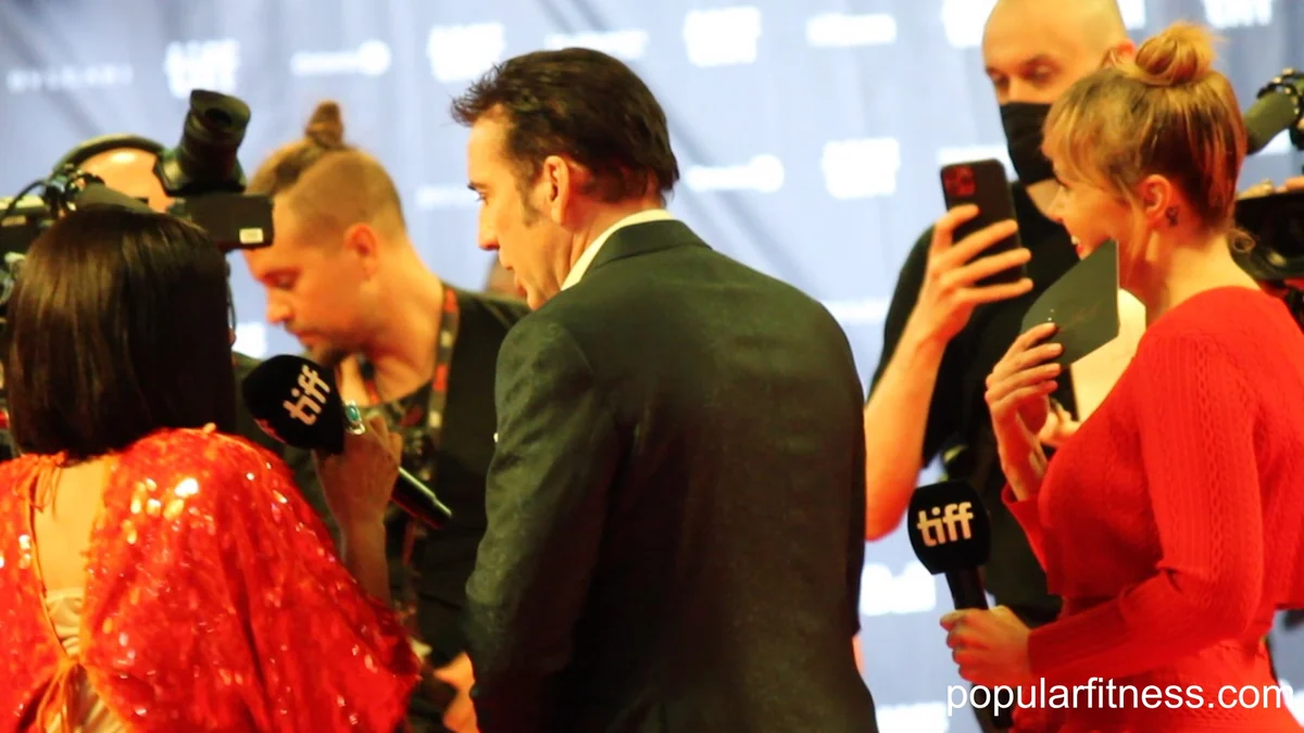 Nicolas Cage vu de dos parmi des journalistes et des caméras sur un tapis rouge