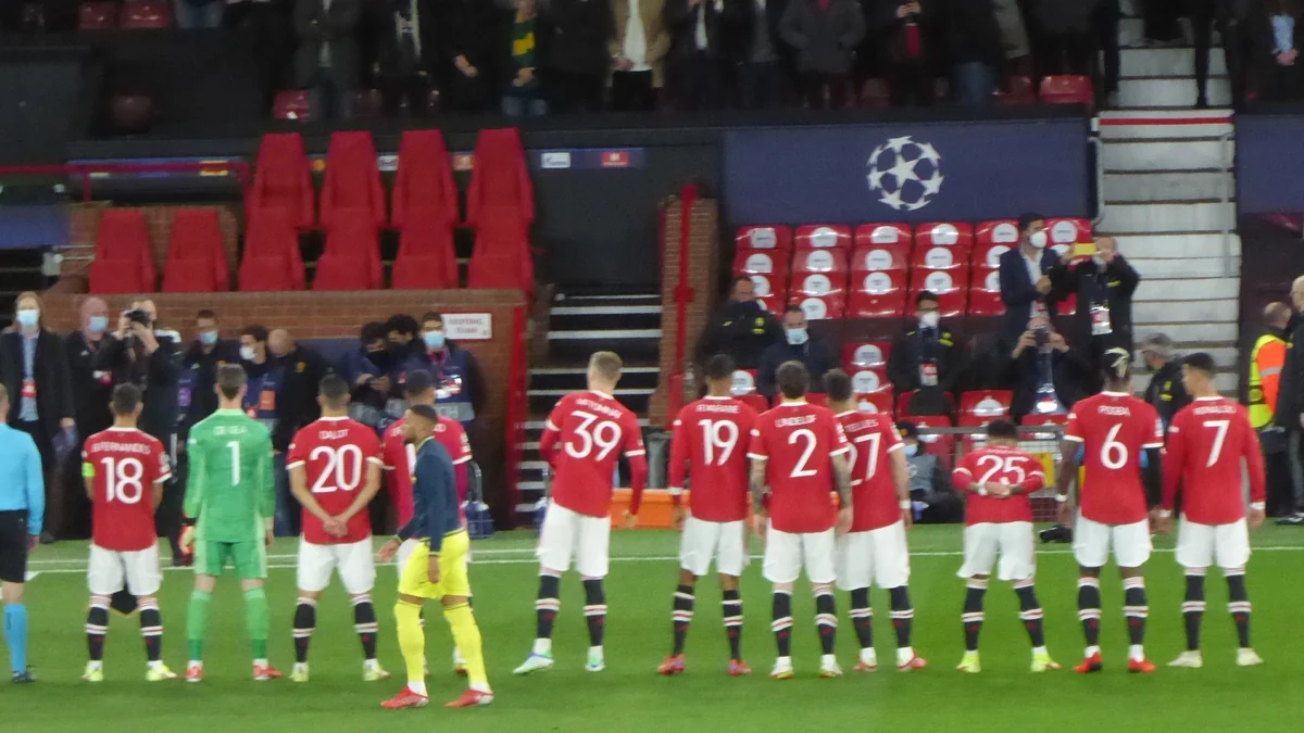 Jogadores do Manchester United e um atleta do Villarreal alinhados no gramado antes de uma partida