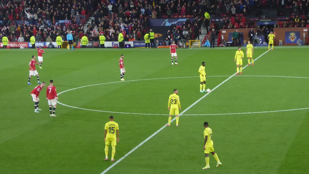 Jogadores do Villarreal e do Manchester United posicionados no círculo central do campo