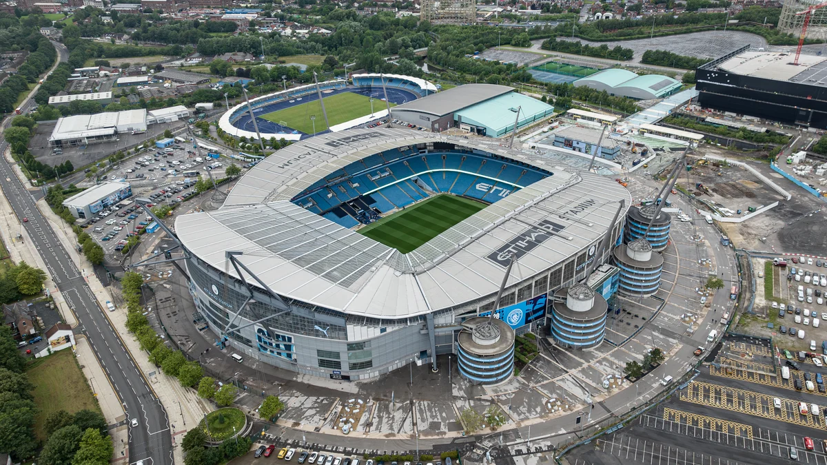 Aerial view of Manchester City’s stadium, showing blue stands, the pitch and surrounding facilities
