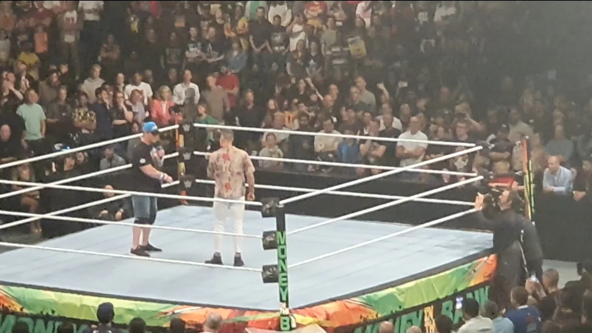 John Cena y otro hombre en un ring rodeado de público.