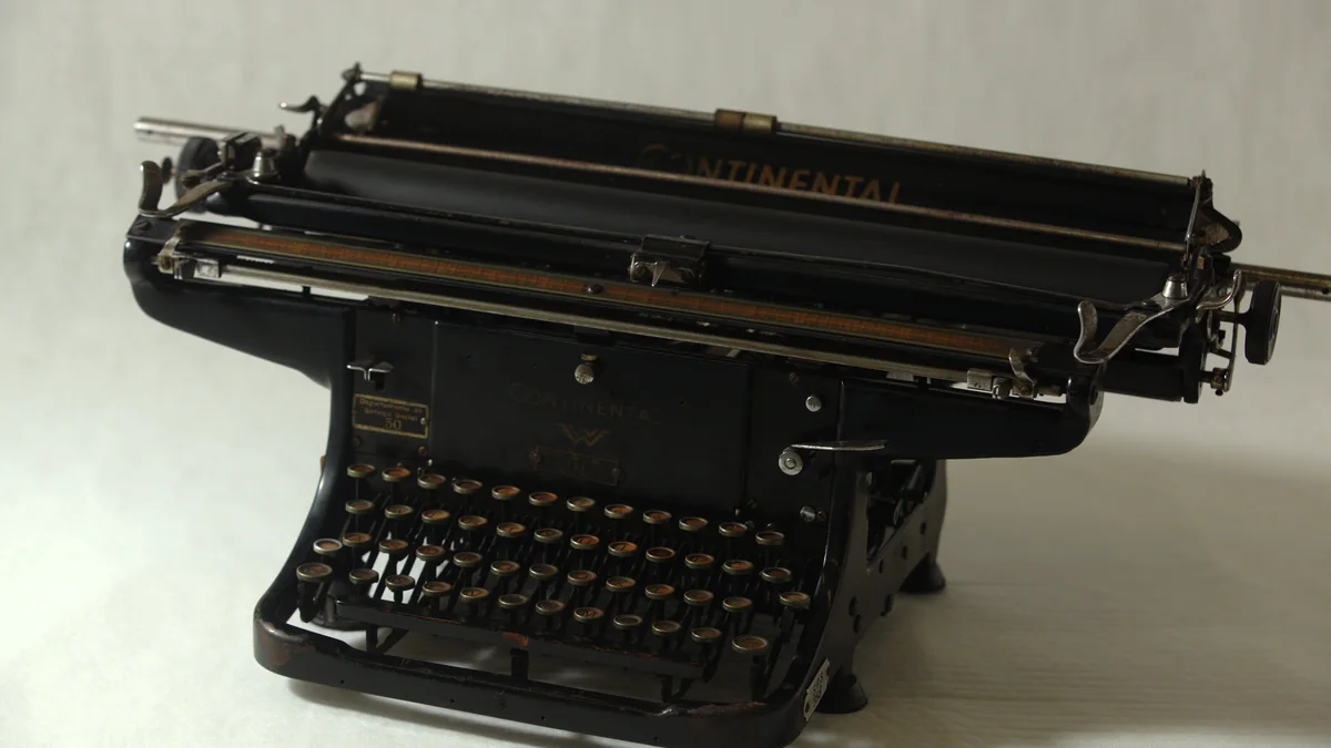 Máquina de escrever antiga preta sobre uma superfície clara