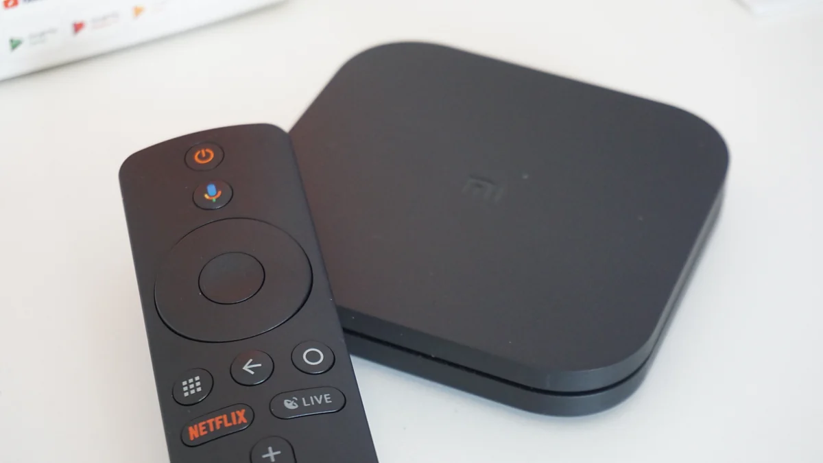 Remote control with a Netflix button in front of a Xiaomi Mi Box S