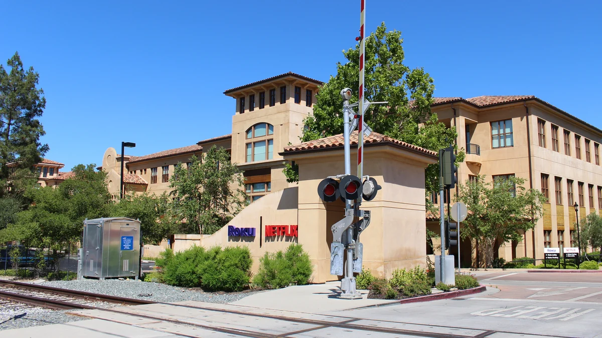 Building with Roku and Netflix signs behind a railroad signal