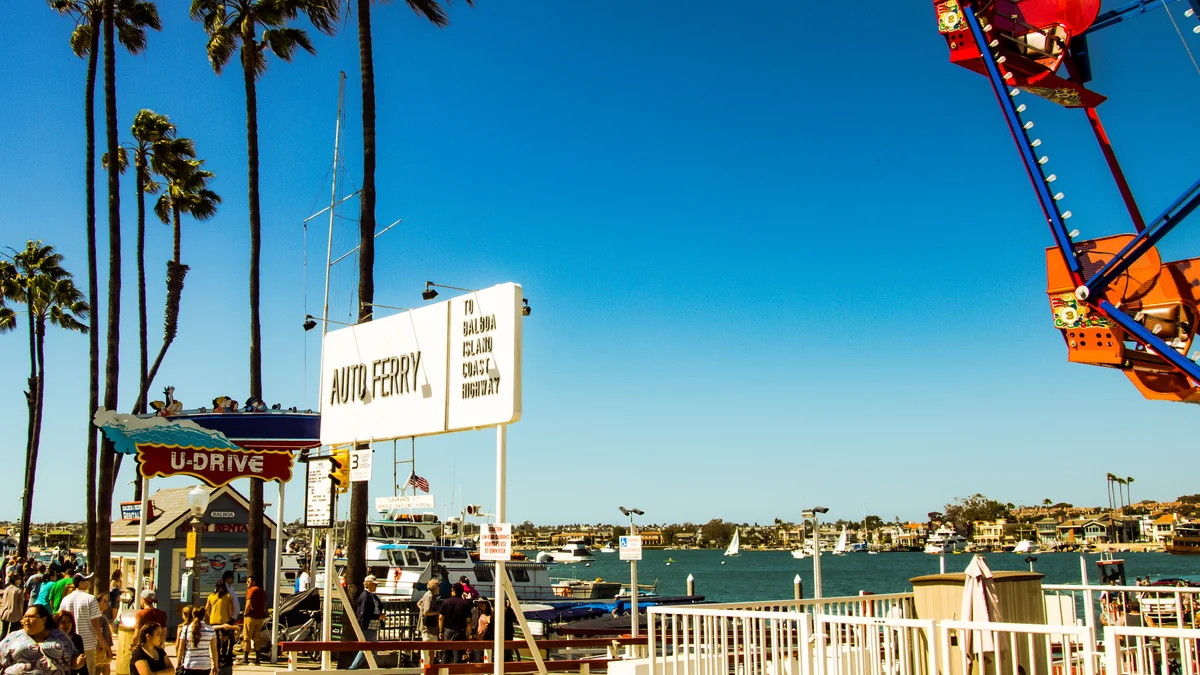 Terminal du Balboa Island Auto Ferry avec des passagers, des bateaux et une grande roue près du port
