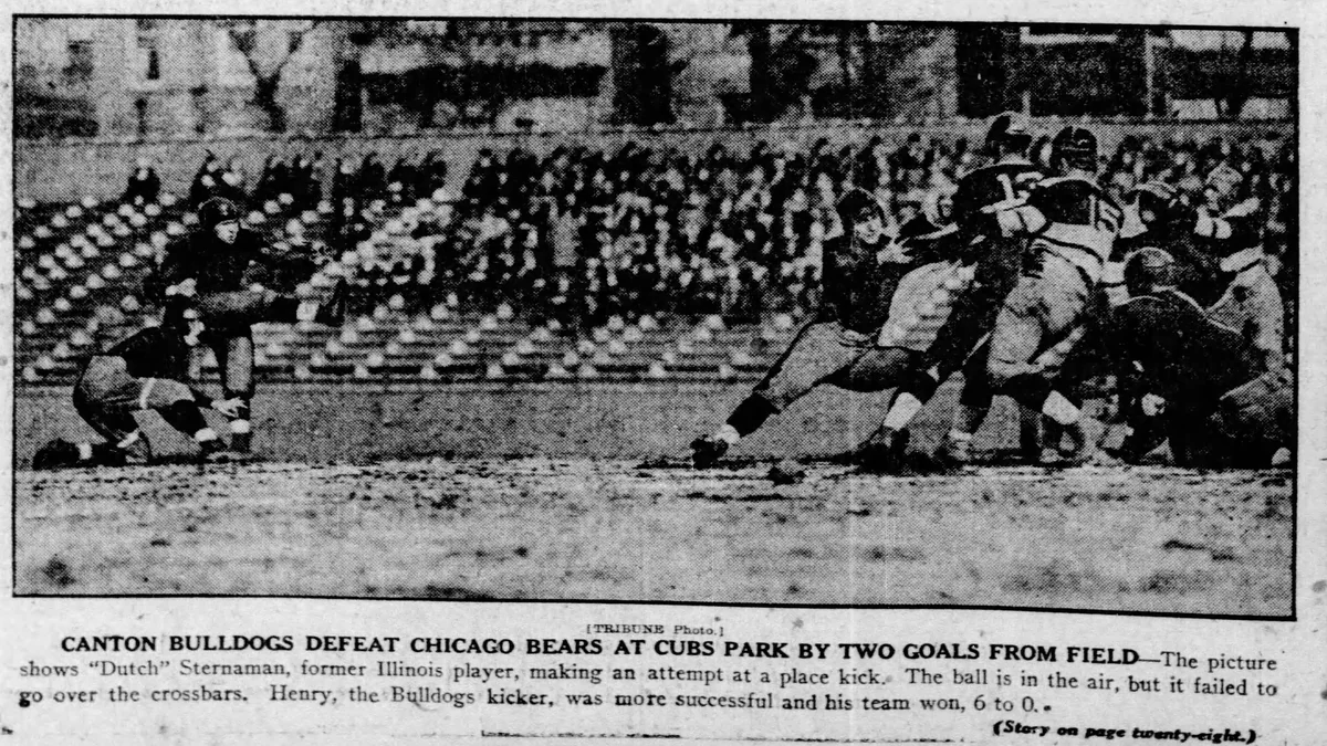 Recorte de jornal em preto e branco com tentativa de chute durante partida entre Canton Bulldogs e Chicago Bears em 1923