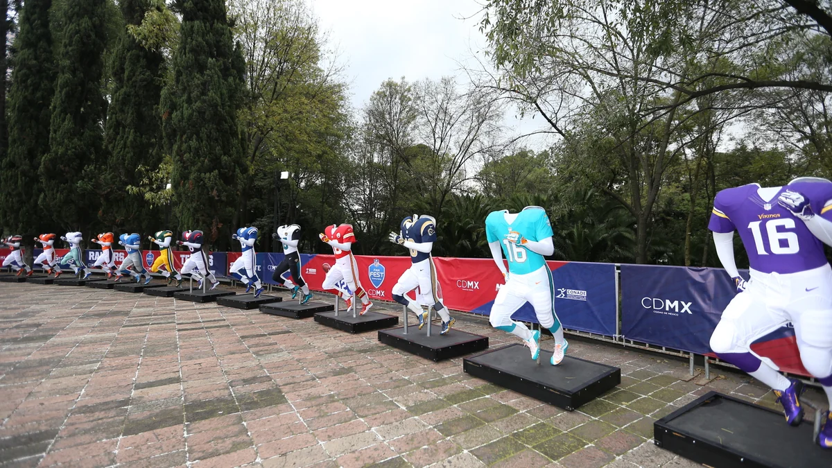 Esculturas de mascotes e jogadores da NFL alinhadas em área arborizada