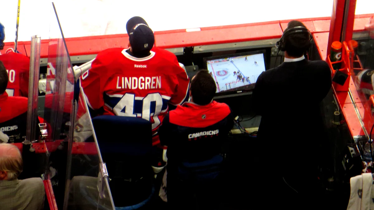 Jugador de los Canadiens con la camiseta de Lindgren frente a un monitor en el banquillo