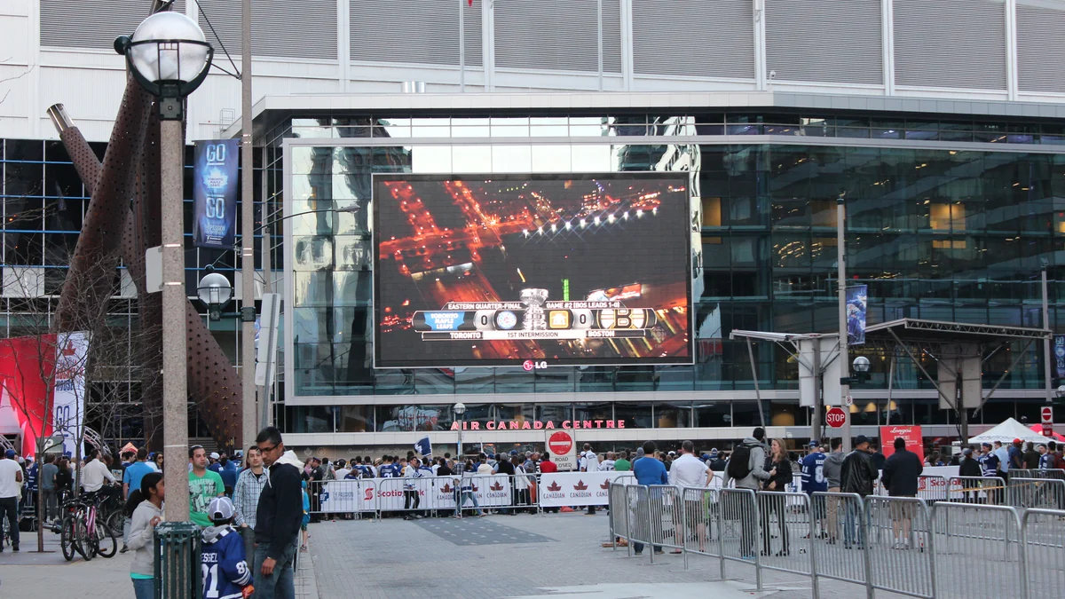 Público reunido ante el estadio de Toronto con un partido de hockey en la pantalla grande
