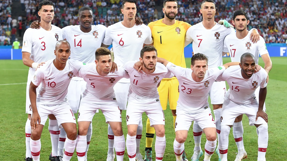 Portugal’s national team poses on the pitch before a match, with Cristiano Ronaldo in the back row.