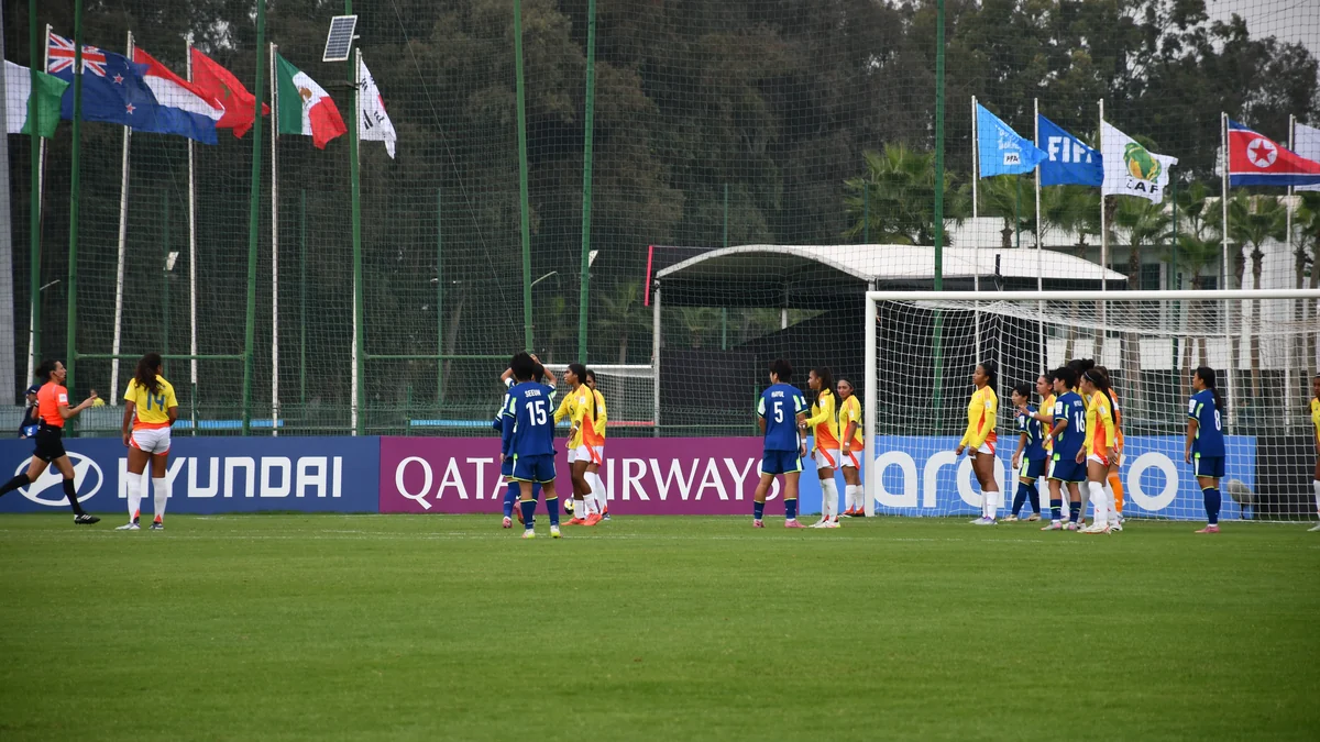 Jugadoras de Colombia y Corea del Sur se ubican en el área durante un partido de fútbol femenino.