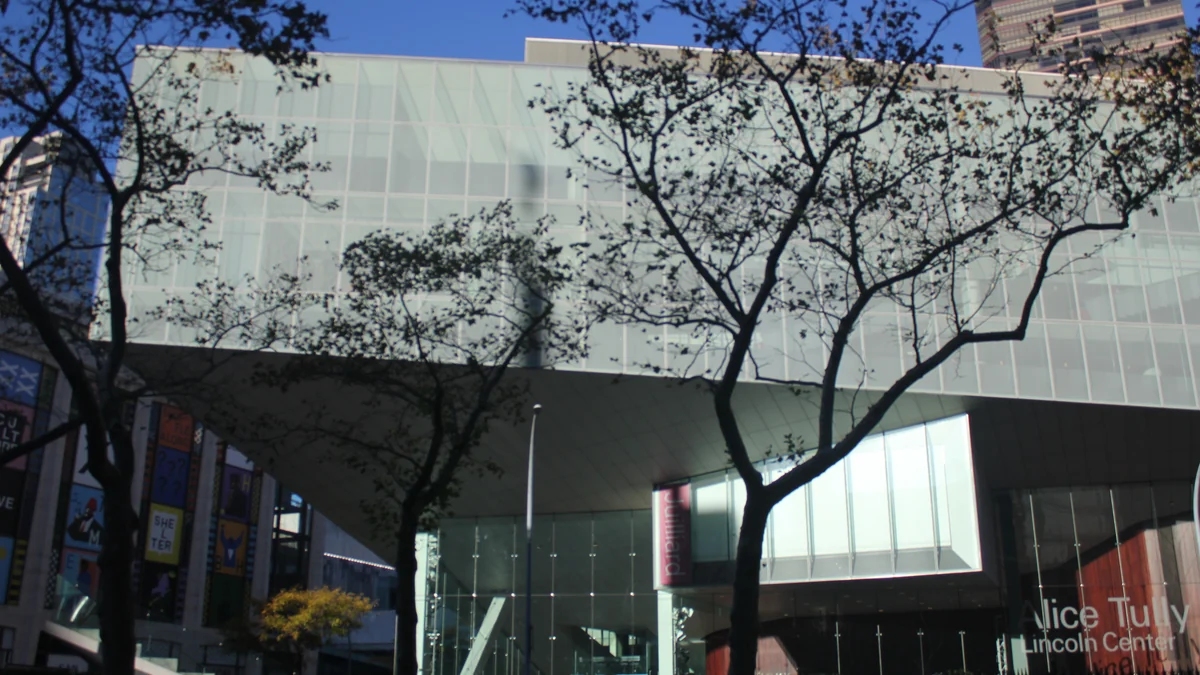 Glass exterior of Alice Tully Hall partly screened by trees