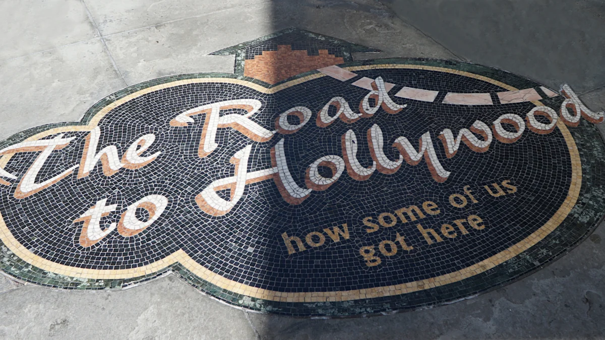 Floor mosaic with the words “The Road to Hollywood” in light lettering on a dark background.