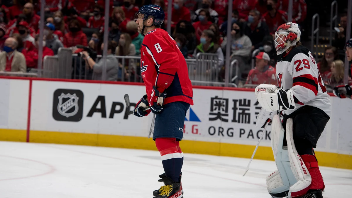 Alex Ovechkin de profil sur la glace devant le gardien des New Jersey Devils portant le numéro 29