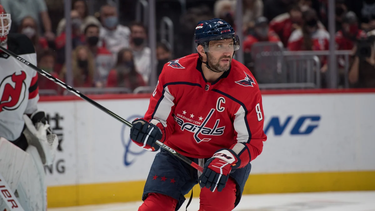 Alex Ovechkin, en maillot rouge et casque bleu des Capitals, tient sa crosse pendant un match