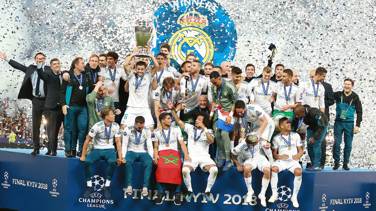 Les joueurs et le staff du Real Madrid célèbrent avec le trophée de la Ligue des champions sous les confettis.