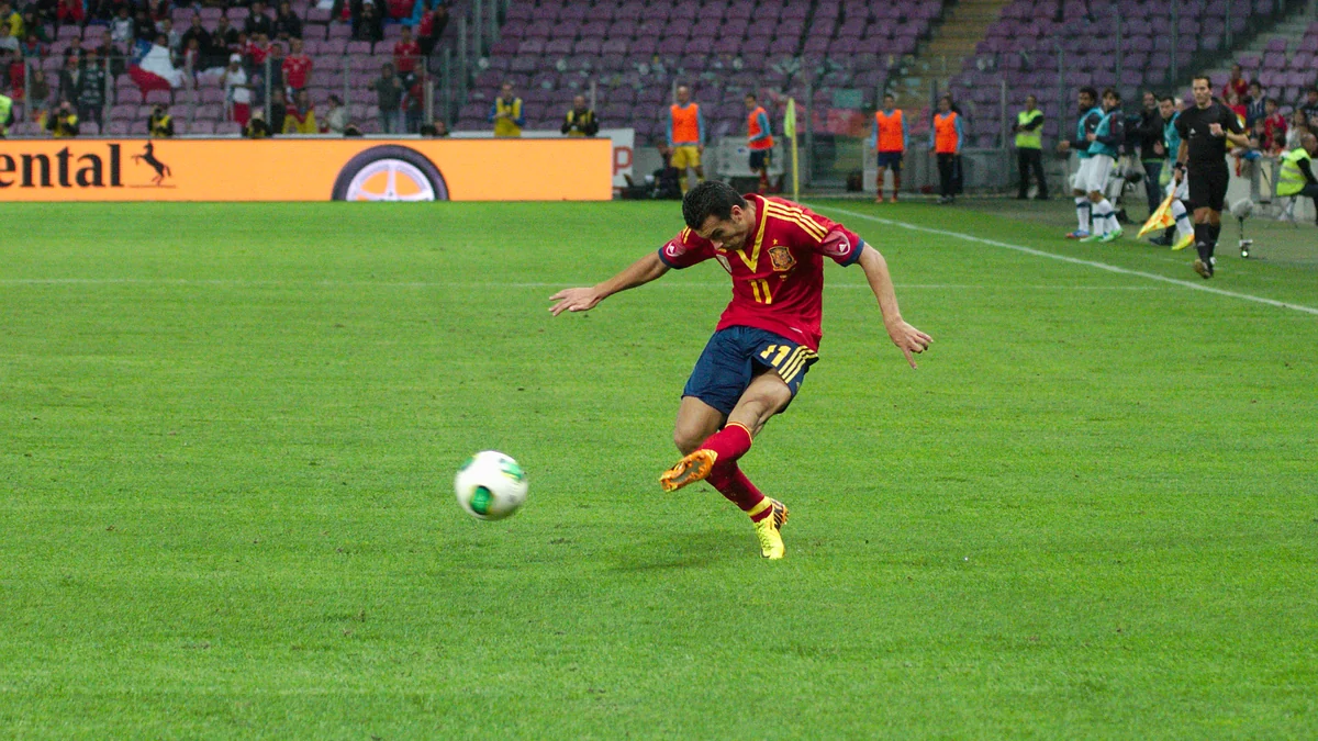 Pedro Rodríguez kicks the ball while wearing Spain’s red national team shirt