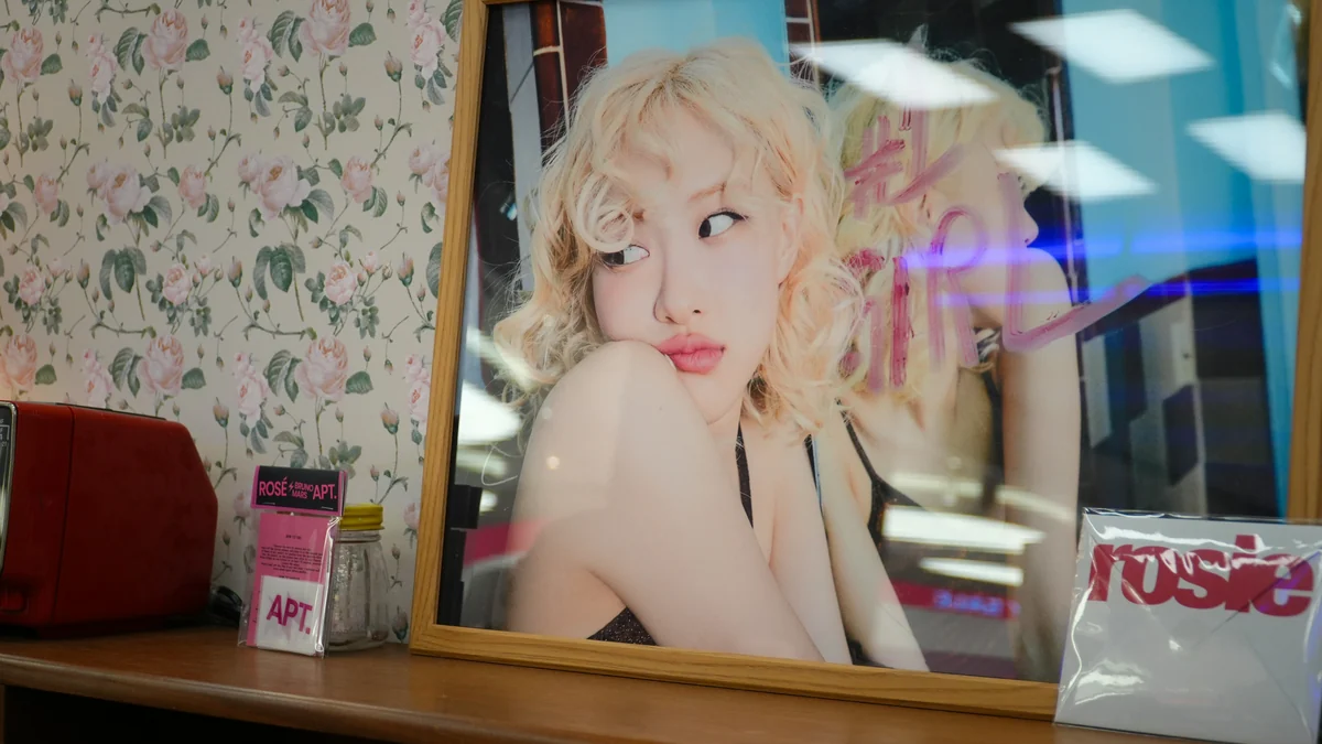Retrato enmarcado de Rosé expuesto junto a artículos en una tienda