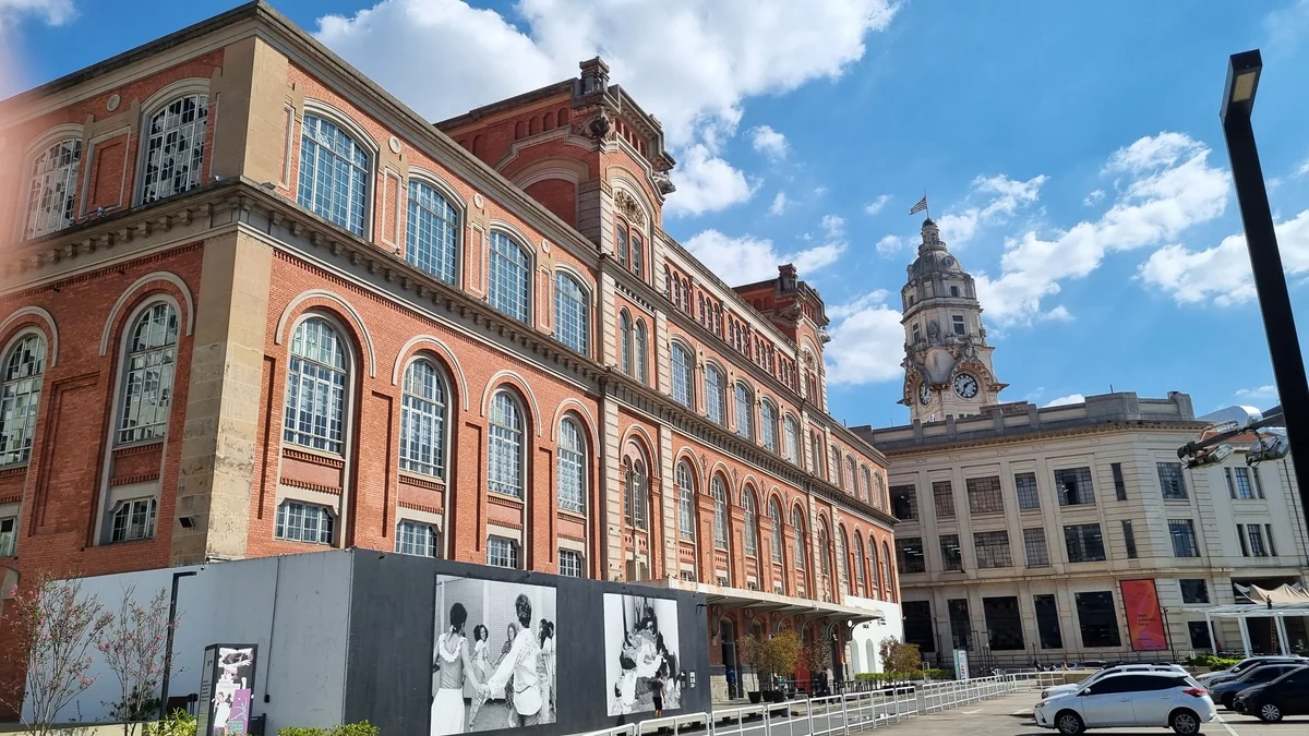 Fachada de tijolos da Pina Estação sob céu azul, com torre histórica ao fundo