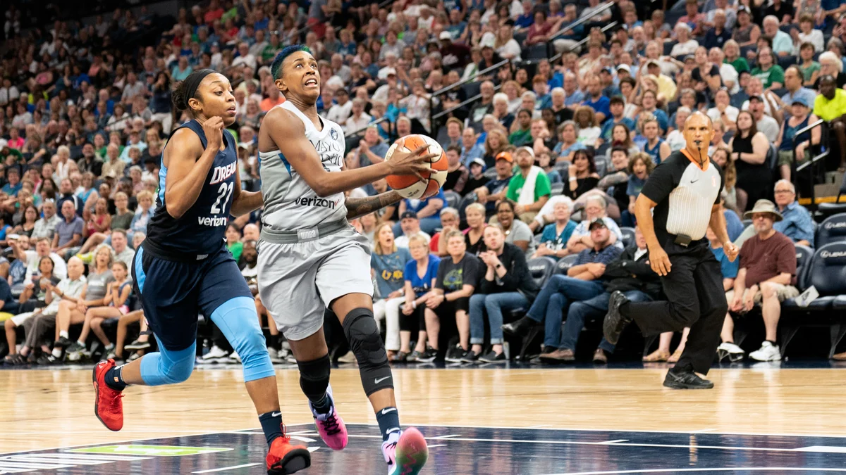 Una jugadora de Minnesota Lynx avanza con el balón seguida por una defensora de Atlanta Dream.