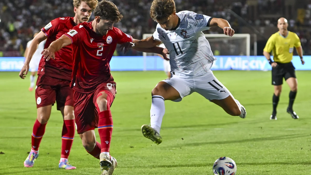 João Félix, con la equipación blanca de Portugal, disputa el balón con dos jugadores de Armenia.