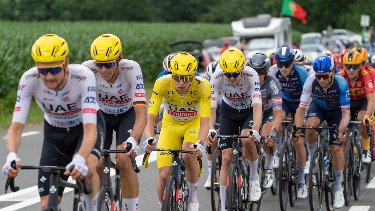 Tadej Pogačar rides in the yellow jersey at the center of the peloton, surrounded by UAE teammates.