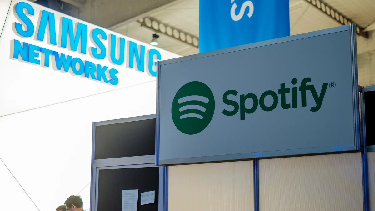 Panel displaying the Spotify logo in front of a Samsung Networks sign.
