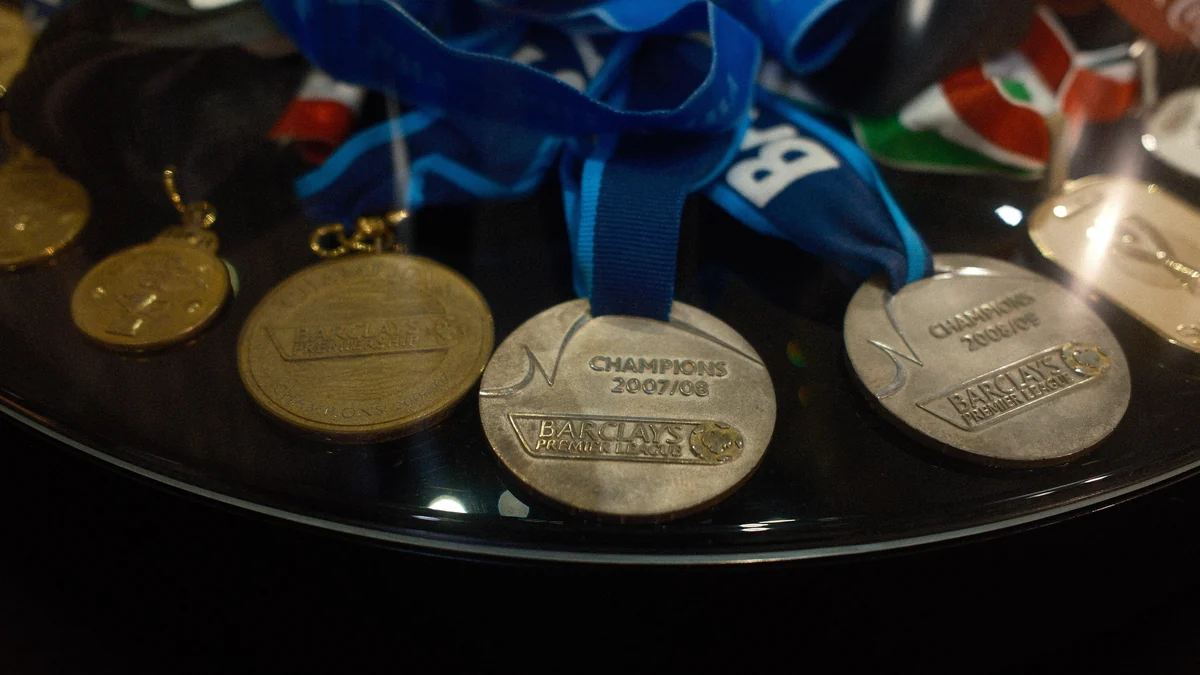 Medalhas da Premier League com fitas azuis dentro de uma vitrine