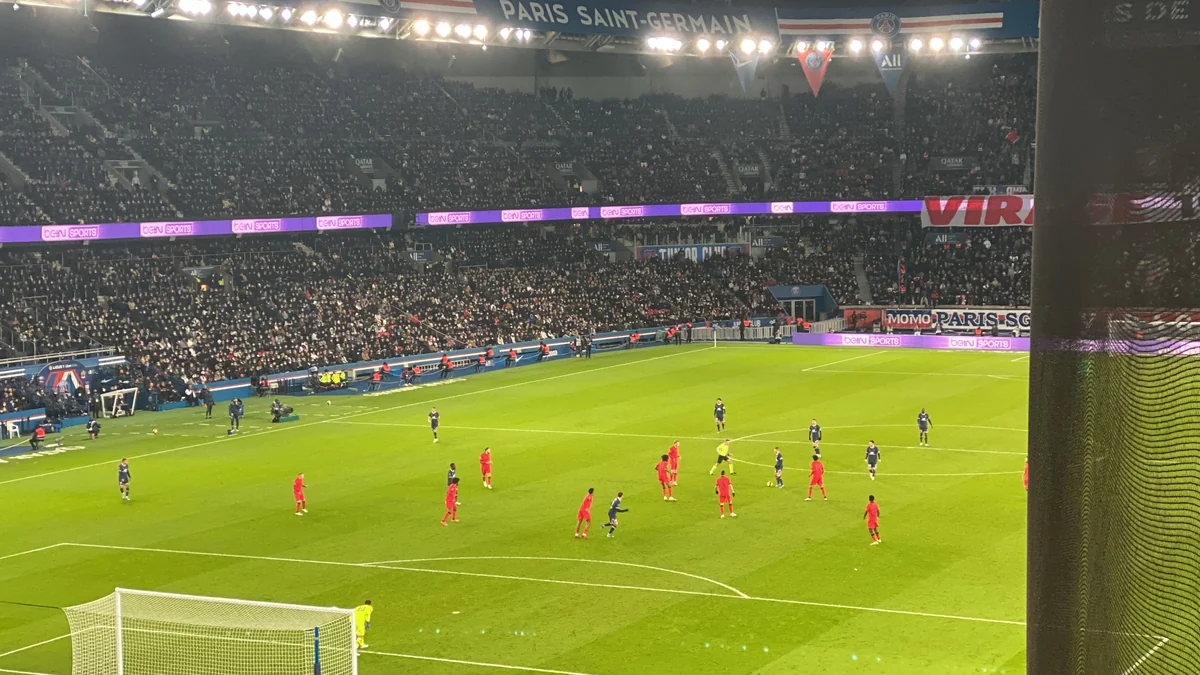 Des joueurs répartis sur la pelouse du Parc des Princes devant des tribunes remplies
