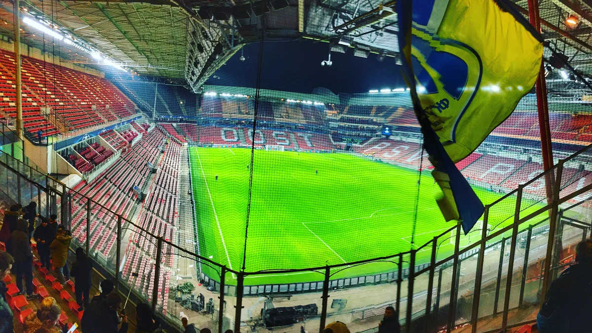 Arquibancadas vermelhas e campo iluminado vistos do alto no Philips Stadion