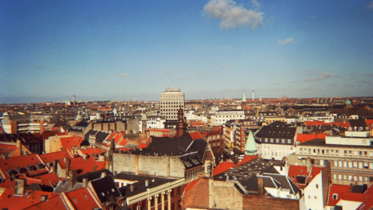 Panorama de Copenhague con tejados rojos y torres bajo un cielo azul