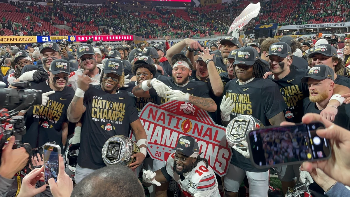 Ohio State players gathered on the field wearing national champions shirts and caps