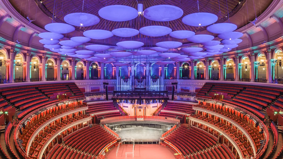 Intérieur vide du Royal Albert Hall avec des rangées de sièges rouges et un éclairage coloré