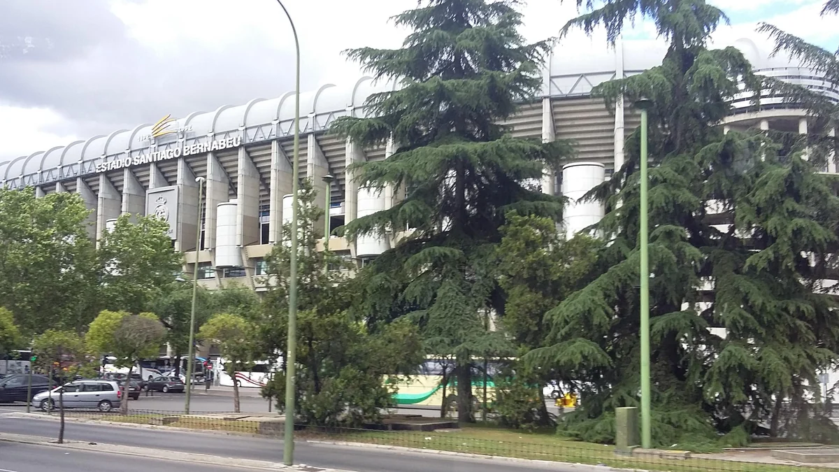 Santiago Bernabéu façade partially obscured by trees