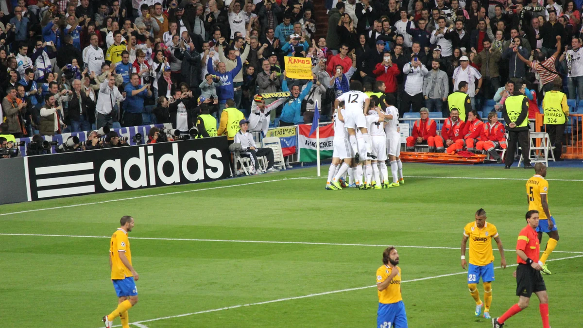 Des joueurs du Real Madrid célèbrent près du poteau de corner devant les supporters