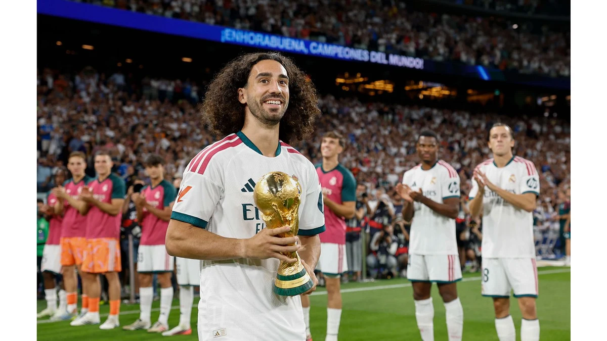 Marc Cucurella holds the World Cup trophy during a tribute at the Bernabéu.