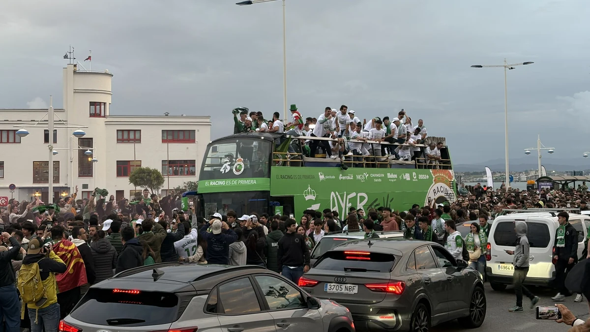 Autobús verde del Racing de Santander rodeado de aficionados durante una celebración pública