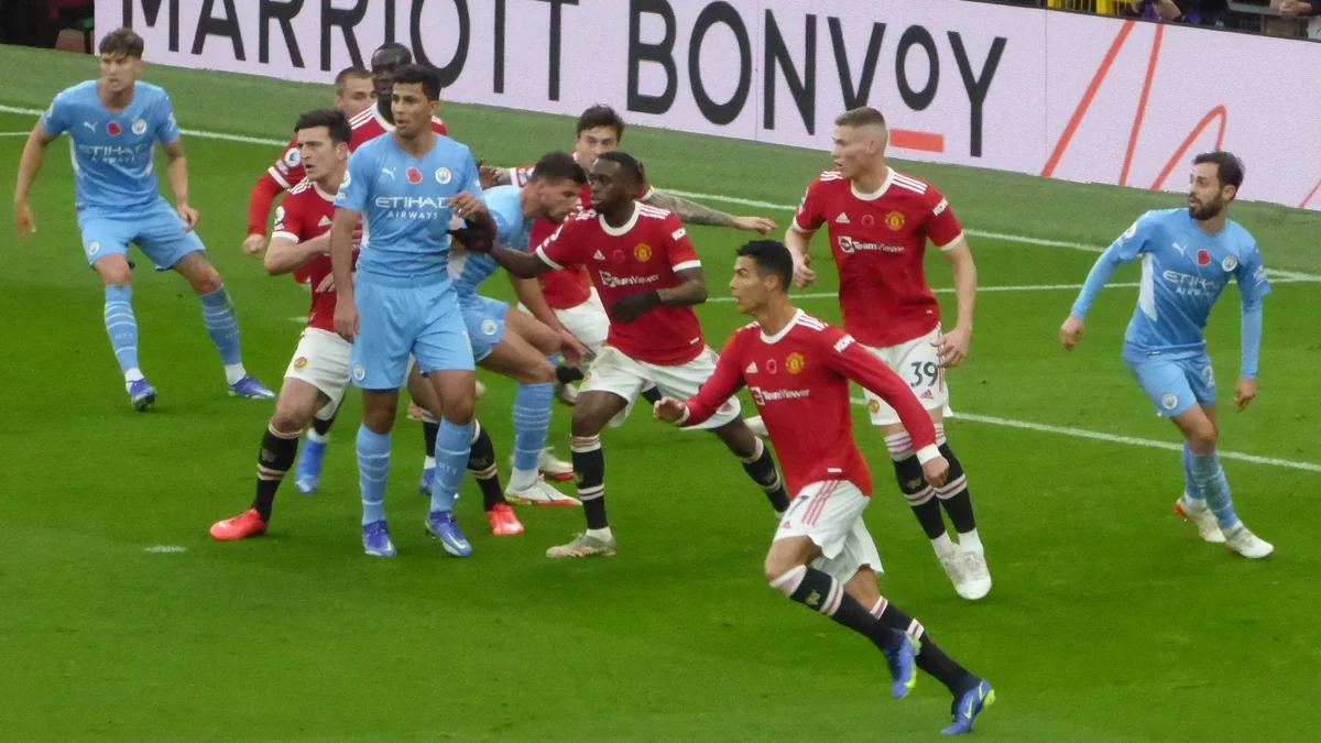 Jogadores de Manchester United e Manchester City disputam espaço na área durante uma partida em Old Trafford.