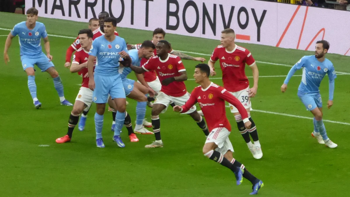 Manchester United and Manchester City players contest space in the penalty area during a match at Old Trafford.