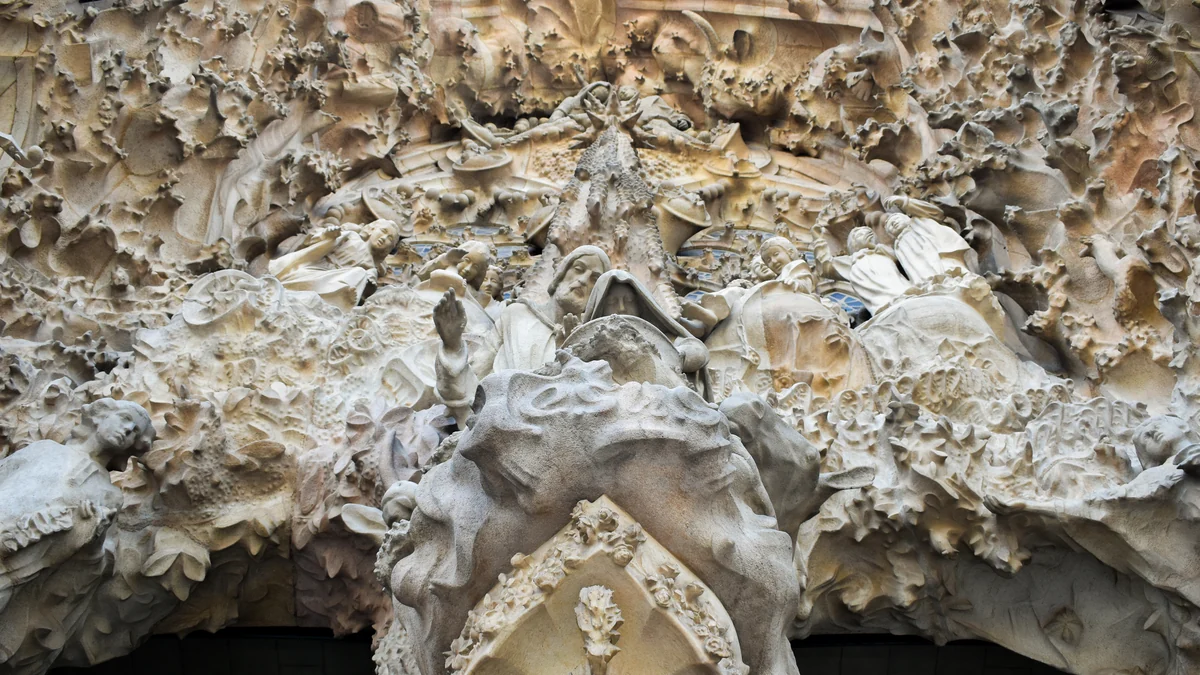 Conjunto de esculturas em pedra no centro da fachada da Natividade da Sagrada Família
