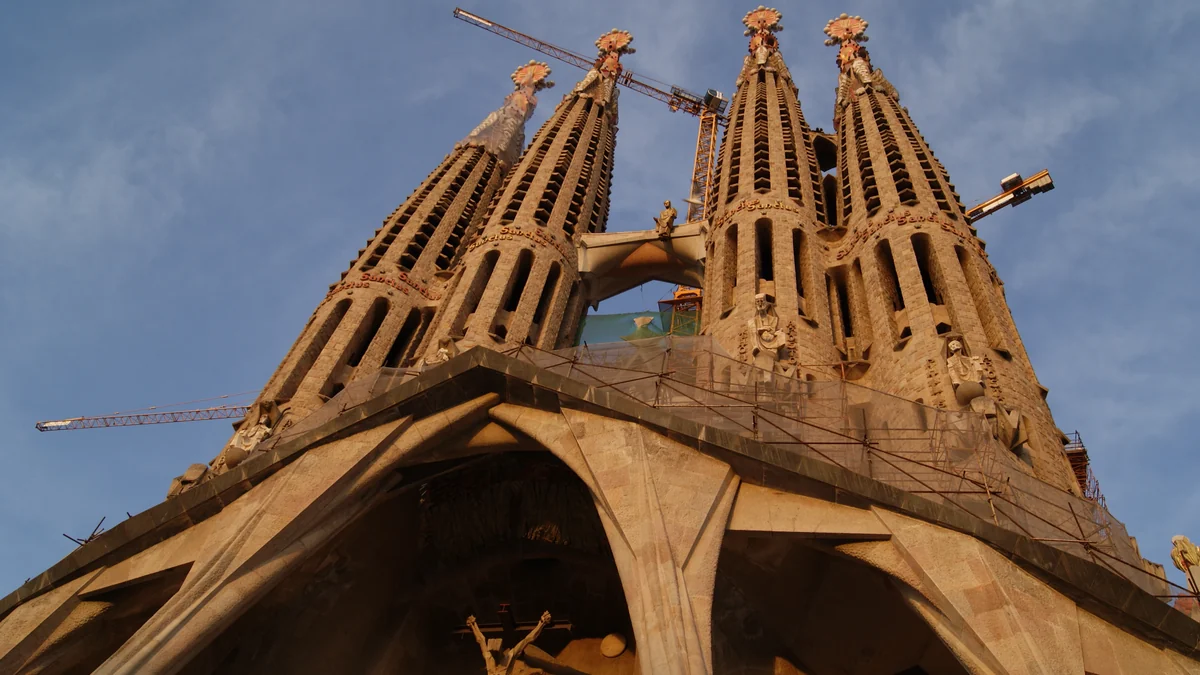 Torres da Sagrada Família vistas de baixo, com vários guindastes ao redor
