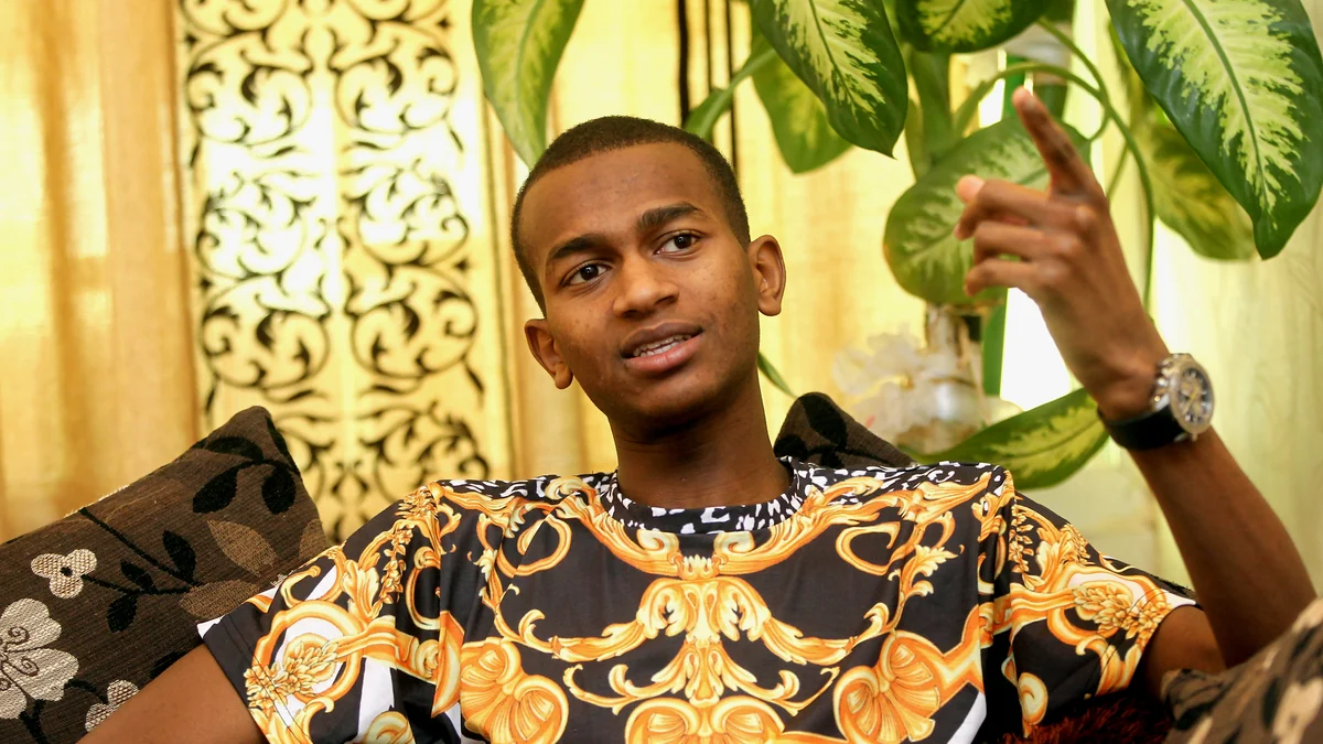 Mutaz Essa Barshim sits on a sofa, speaking and pointing upward with one hand