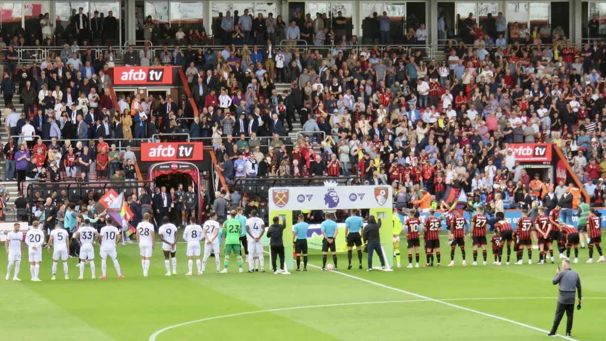 Bournemouth and West Ham players lined up on the pitch in front of the stands