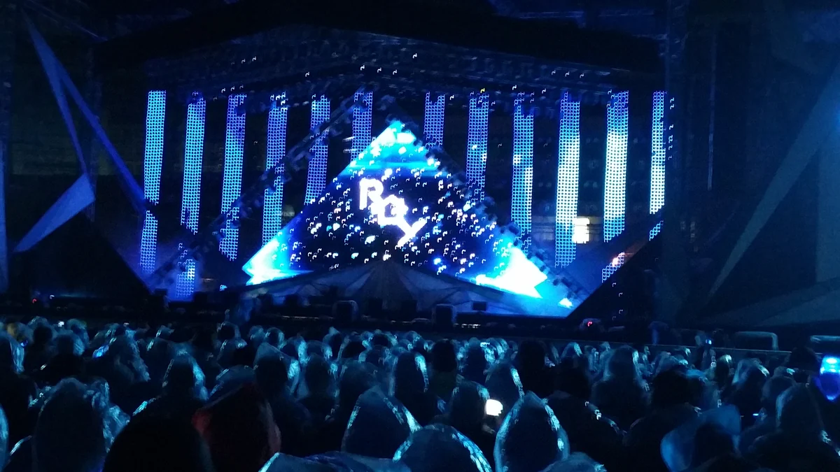 Public face à une scène de concert éclairée en bleu