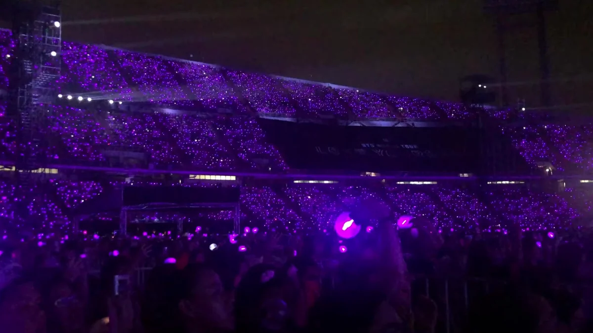 Packed stadium with stands covered in purple lights