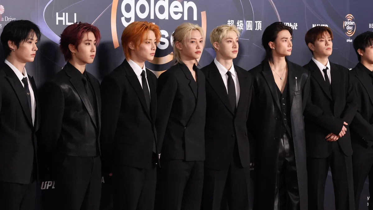 Los integrantes de Stray Kids vestidos de negro ante el panel de los Golden Disc Awards