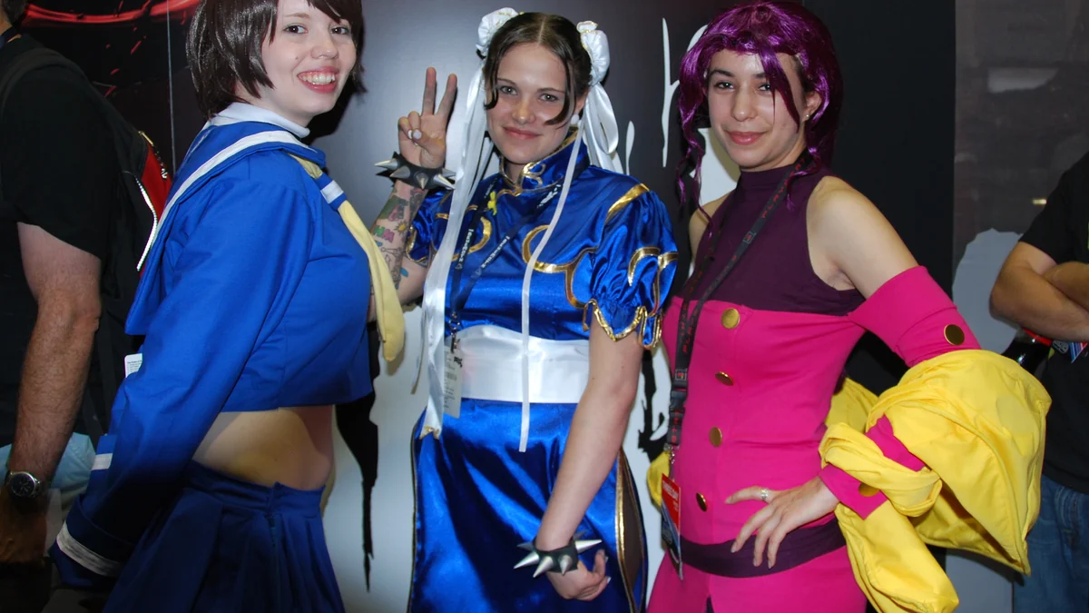 Three cosplayers pose in colorful outfits inspired by Street Fighter characters