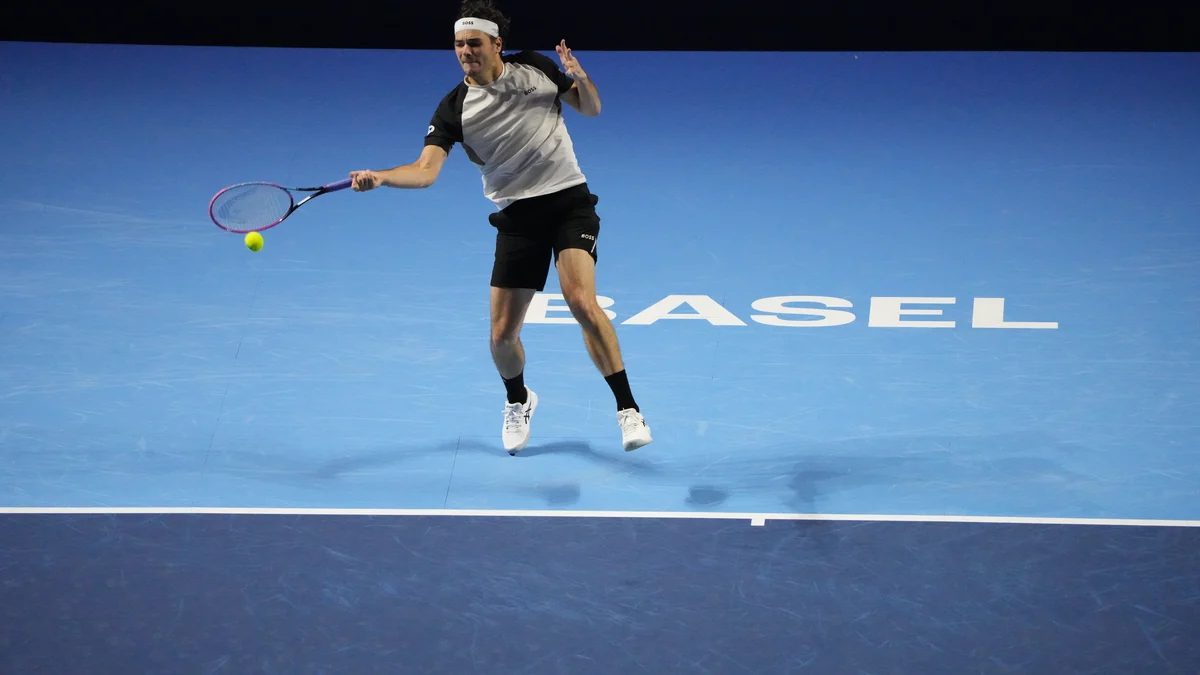 Taylor Fritz frappe un coup droit en suspension au-dessus d’un court bleu