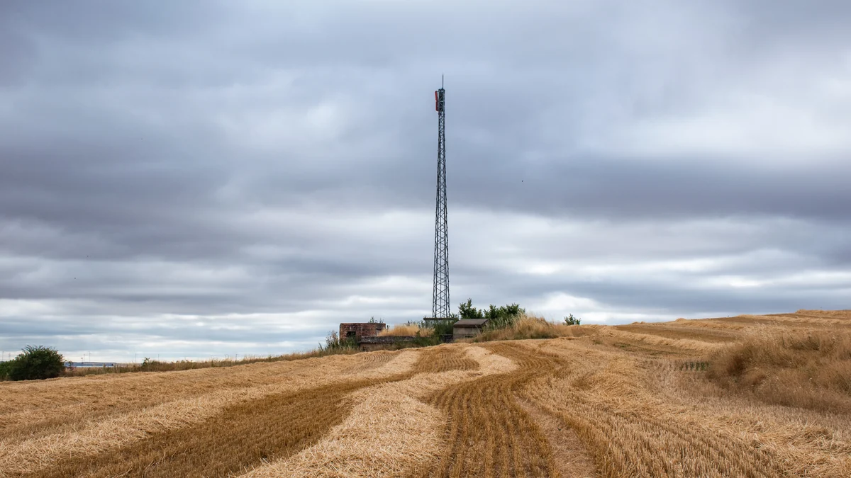 Torre de repetidor de TDT no alto de um campo de cereal colhido